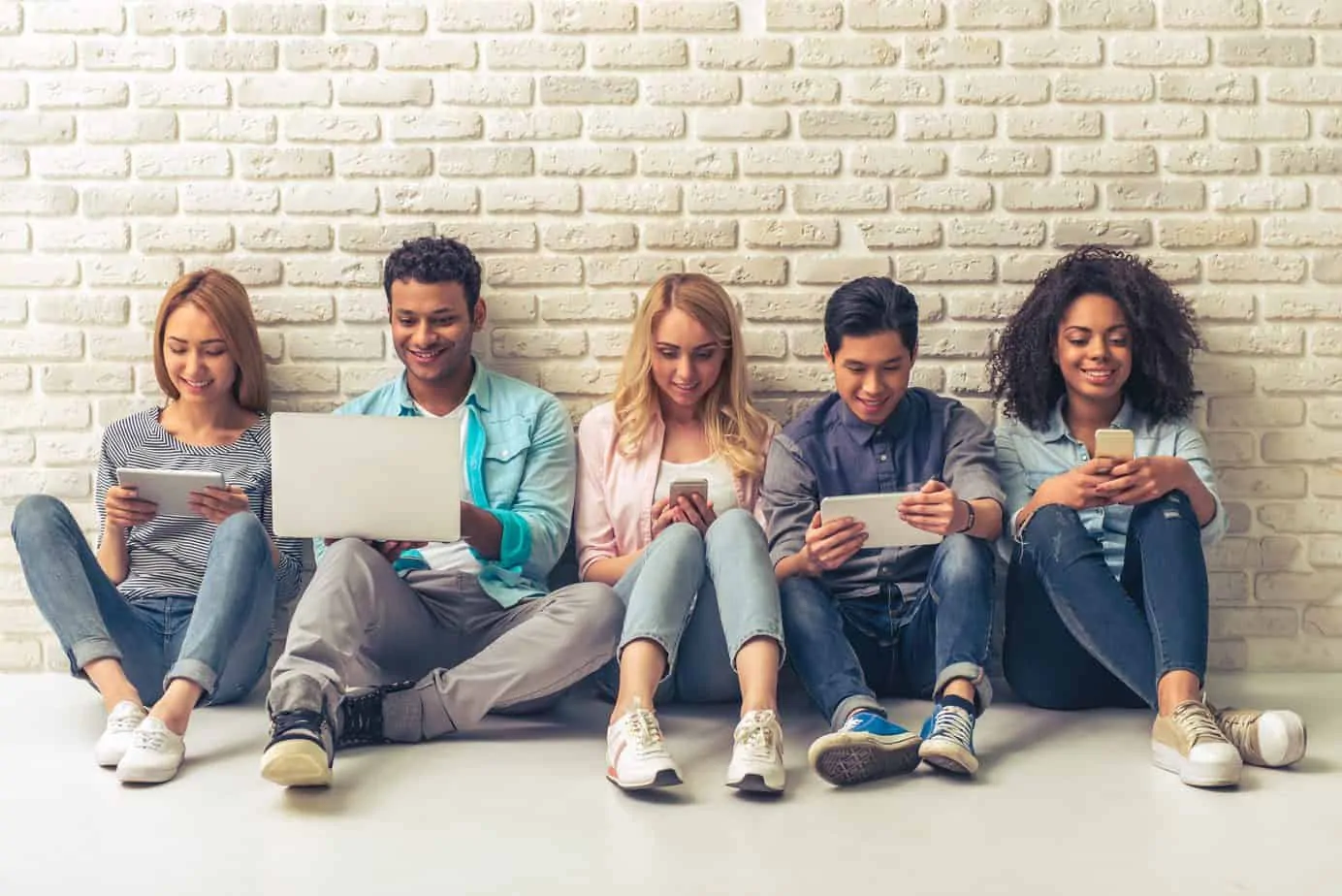 group of friends each on a laptop, tablet or phone playing online casino games