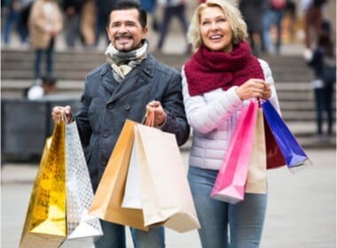 a couple of tourists carrying shopping bags