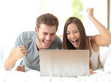 happy couple playing Banana Jones on their laptop