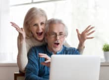 older couple winning online casino games on their laptop