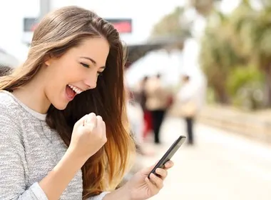 happy woman winning while playing online casino games on her phone