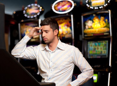 man in a land-based casino looking confused and disappointed