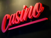 The word casino written in cursive from bottom left to top right. The word is in red with pink highlights