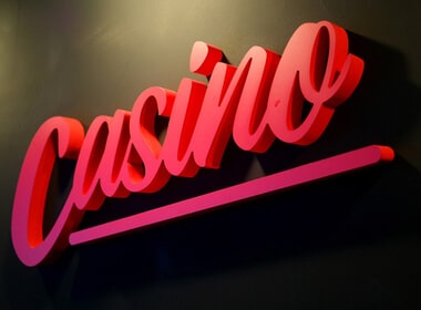 The word casino written in cursive from bottom left to top right. The word is in red with pink highlights