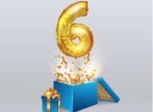 gold balloon in the shape of 6 coming out of a blue gift box with gold confetti