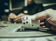 a man showing ace and king, a very strong two-card hand in Pai Gow Poker