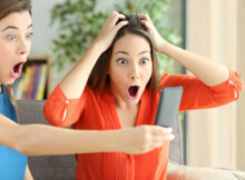 two women looking at their phone in shock over the amazing promotion they found