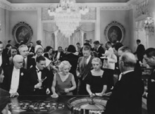 black and white photo of upper class people playing roulade at land-based casino from long ago