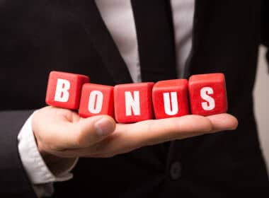 man in suit holding red cubes with bonus imprinted on the cubes