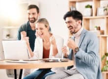 three young people, two men and one woman, celebrating a big win at an online casino.