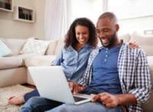 young couple having fun together playing on their laptop