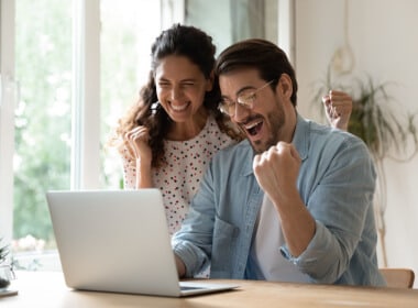 a couple enjoying a win playing online casino games on their laptop