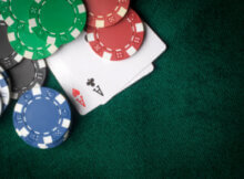 green, blue, and red casino chips plus two aces which is the bets hand to split in blackjack