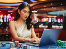 attractive woman playing on a laptop casino while at a land-based casino