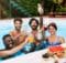 six young adults, three women and three men, enjoying the pool with drinks at a hotel resort