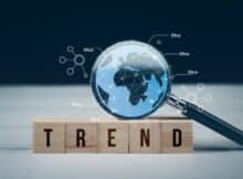 a magnifying glass magnifying the world as if from outer space and five blocks spelling trend