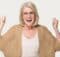 A very happy middle-aged woman with long blond hair smiling toward the camera