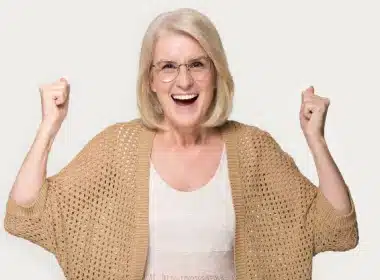 A very happy middle-aged woman with long blond hair smiling toward the camera