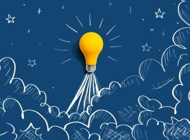 a yellow light bulb suspended in the air above blue clouds representing innovation and creativity