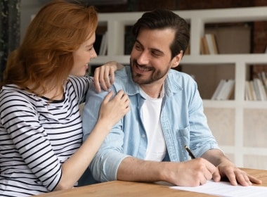 a young couple smiling at each other after they have made a decision they both agree on.